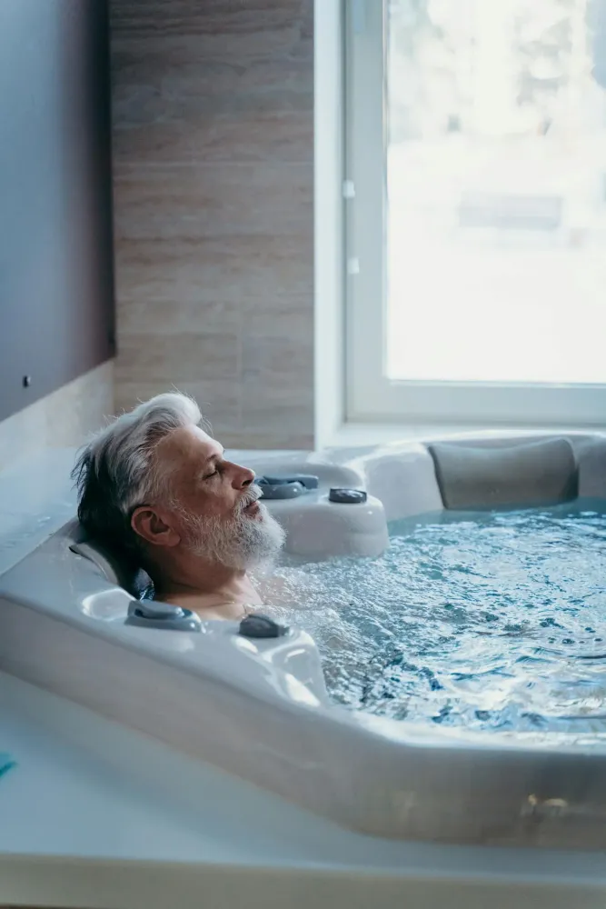 Mężczyzna leży w wannie w trakcie kąpieli wirowej