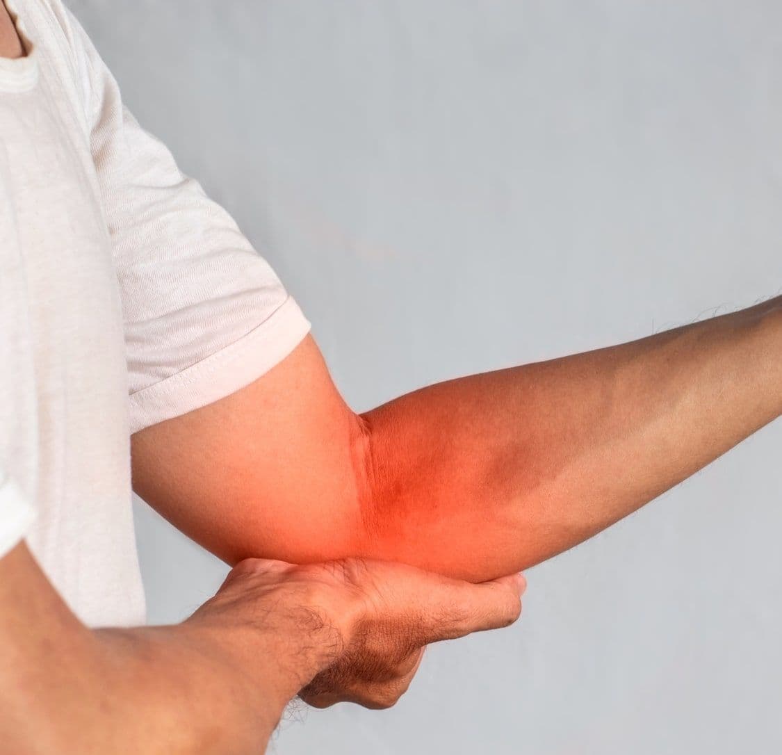 Mężczyzna trzyma się za staw łokciowy