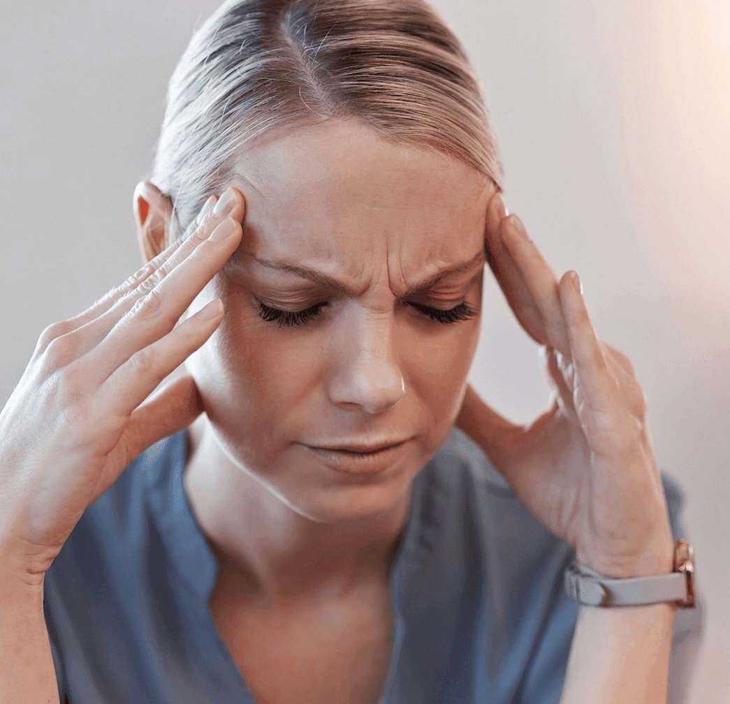 Kobieta trzymająca się za skronie z powodu bólu głowy