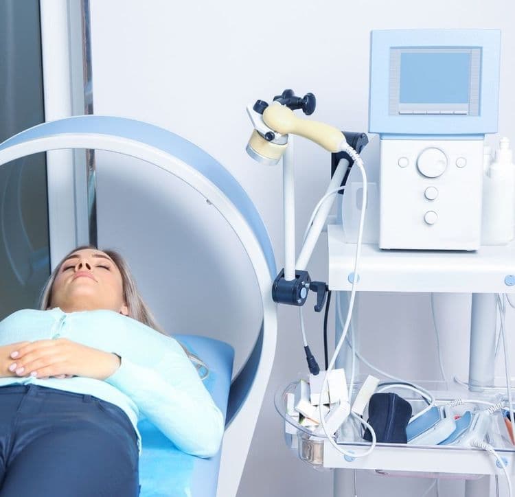 kobieta leży na łóżku w trakcie zabiegu pola magnetycznego