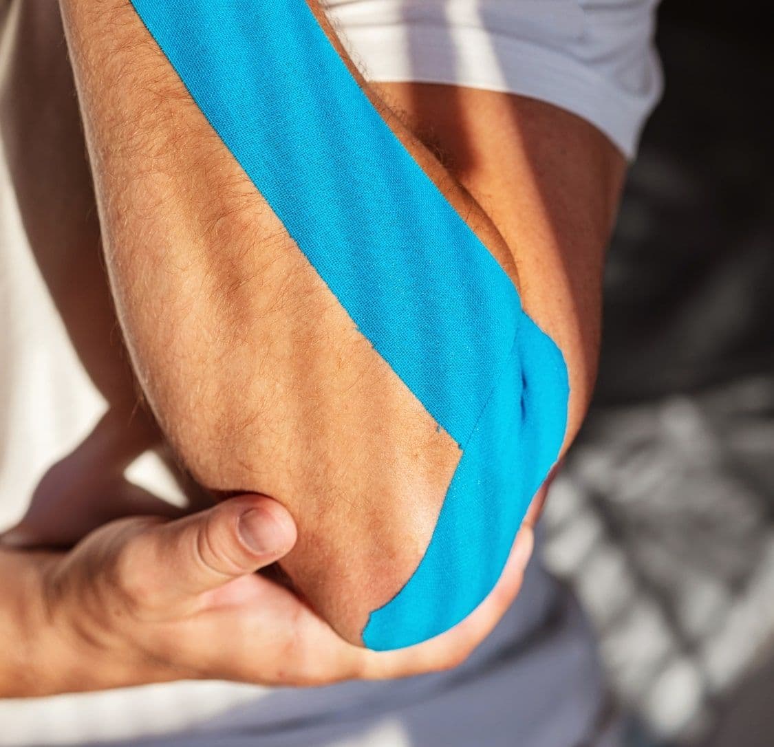 Naklejony taśmy kinesiotaping na łokieć